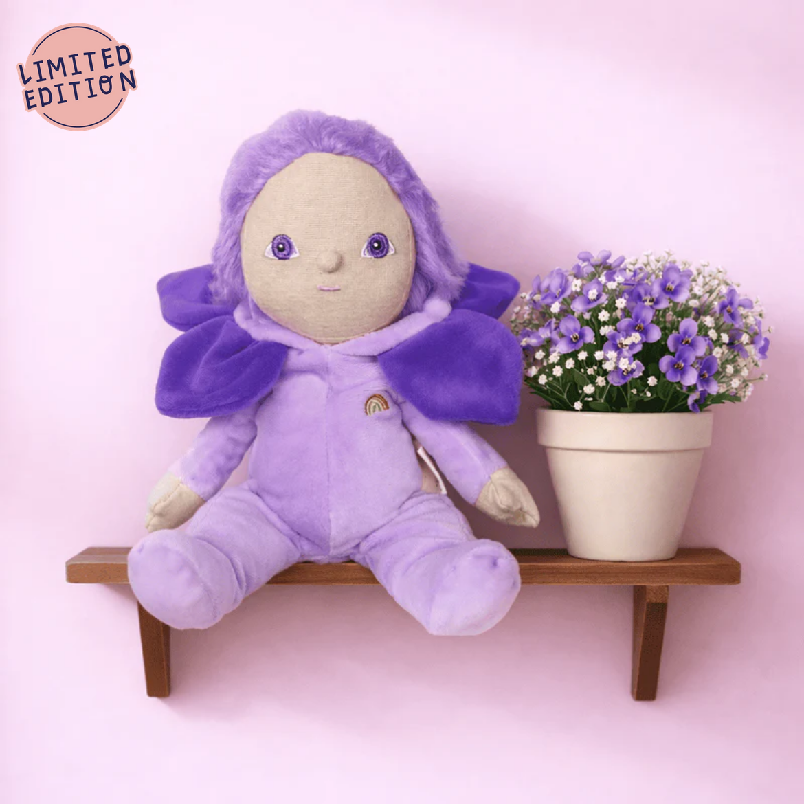 Purple plush toy with a flower pot on a pink background