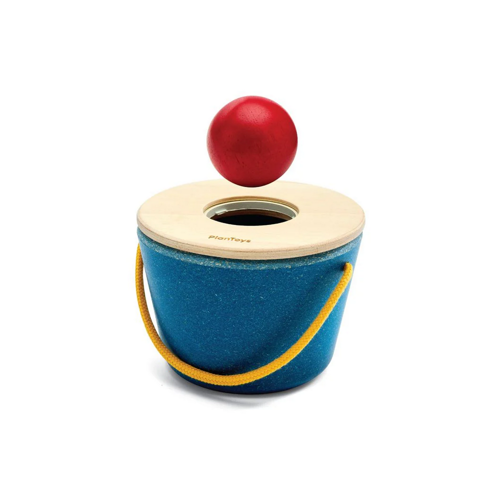 Blue wooden toy with a red ball on top against a white background