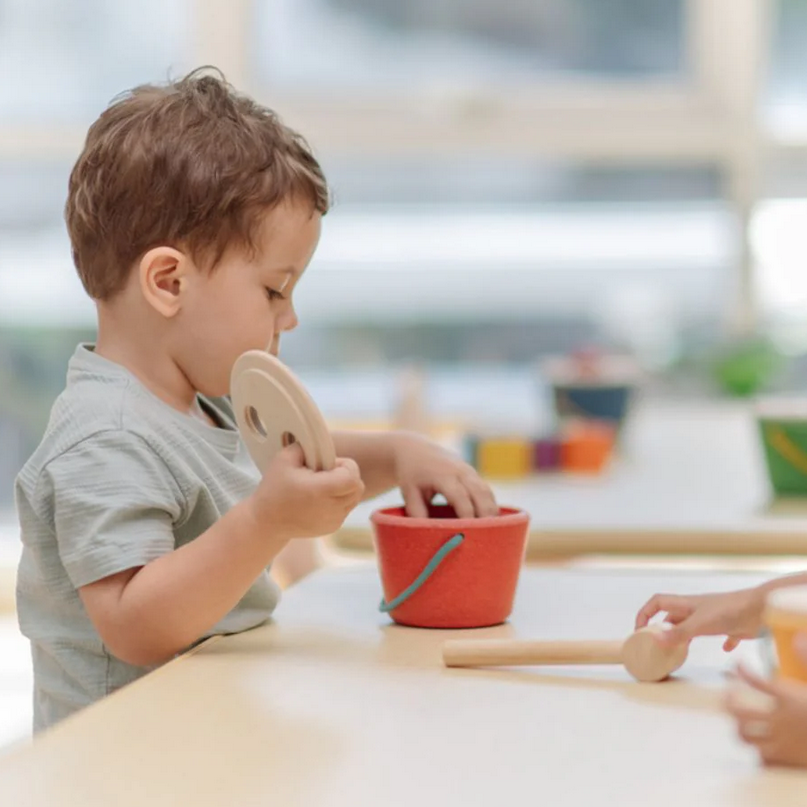Child playing with toys at a table in a classroom setting