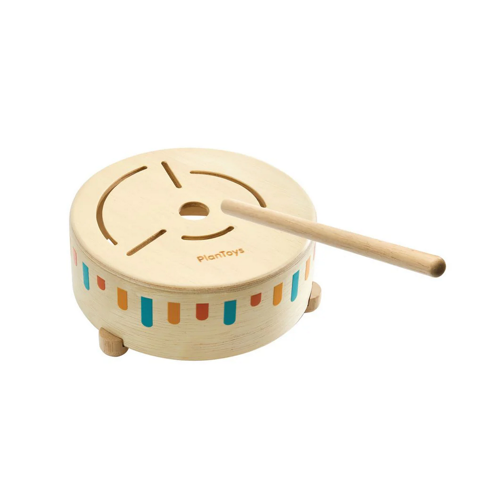 Wooden toy drum with colorful stripes and a drumstick on a white background