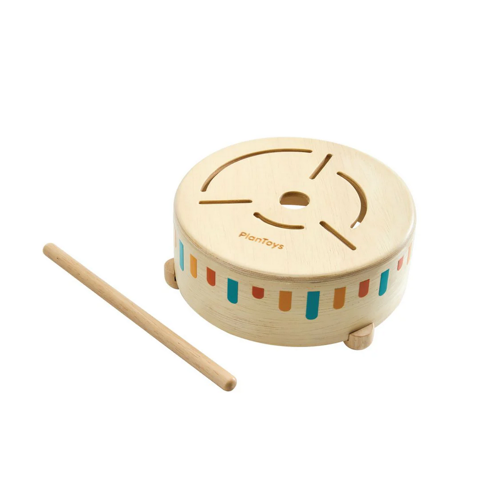 Wooden toy drum with colorful stripes and a drumstick on a white background