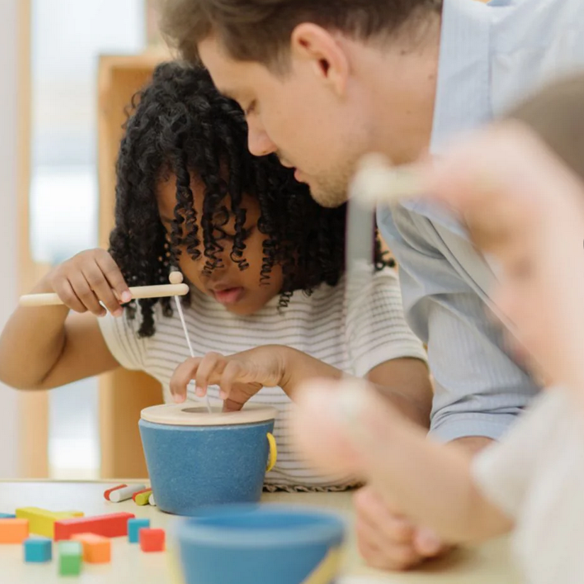 Man and child playing with educational toys at a table