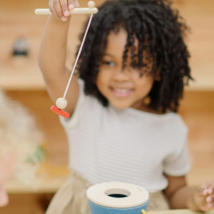 Child playing with a small toy in a classroom setting