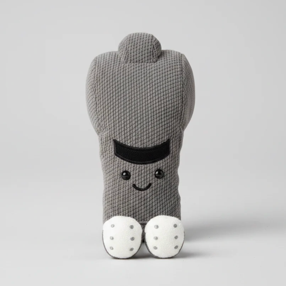 Gray stuffed toy whistle with a smiling face on a light gray background