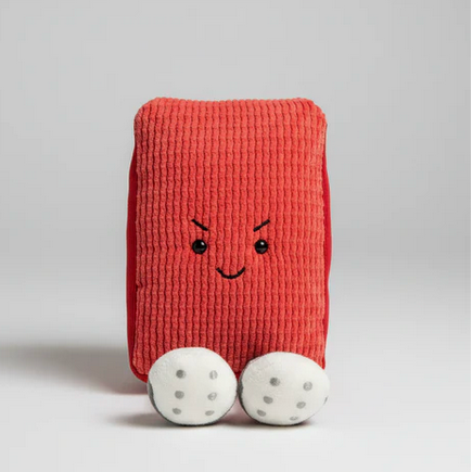 Red plush toy with a face on a gray background