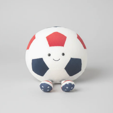Plush toy soccer ball with a smiling face on a gray background