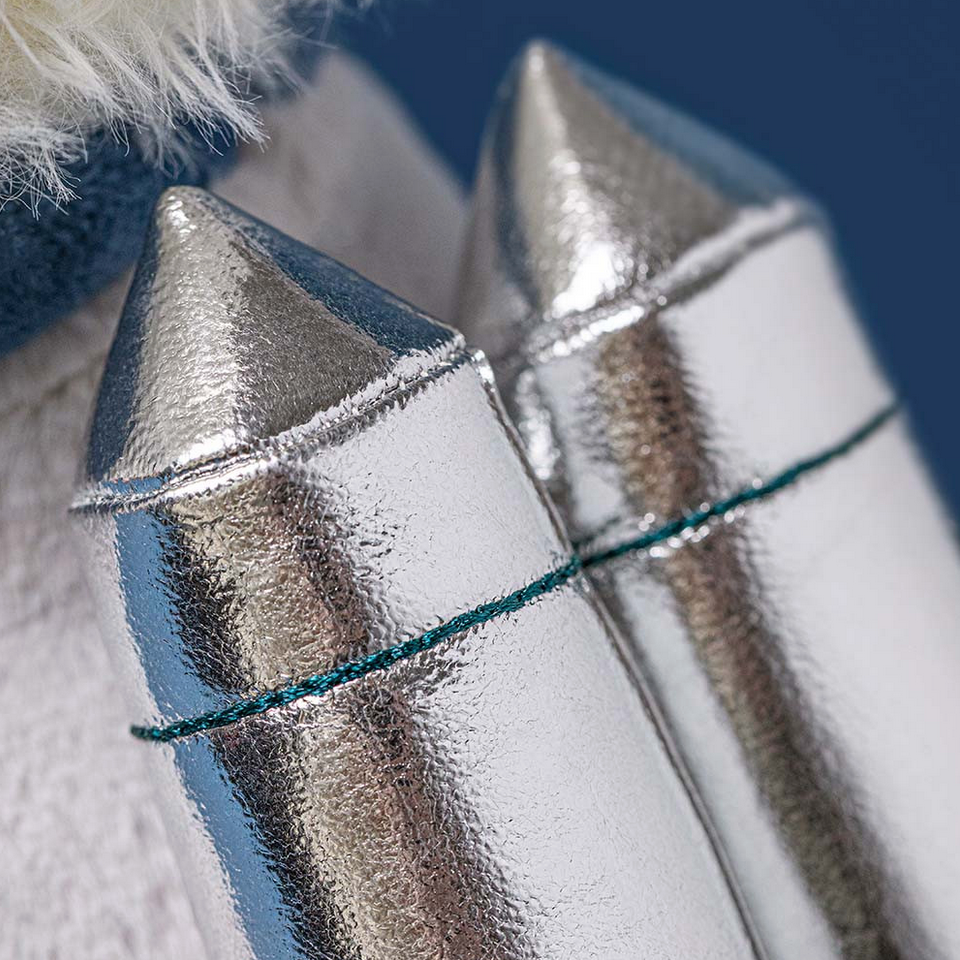 Close-up of a silver dog collar with pointed ends on a blue background