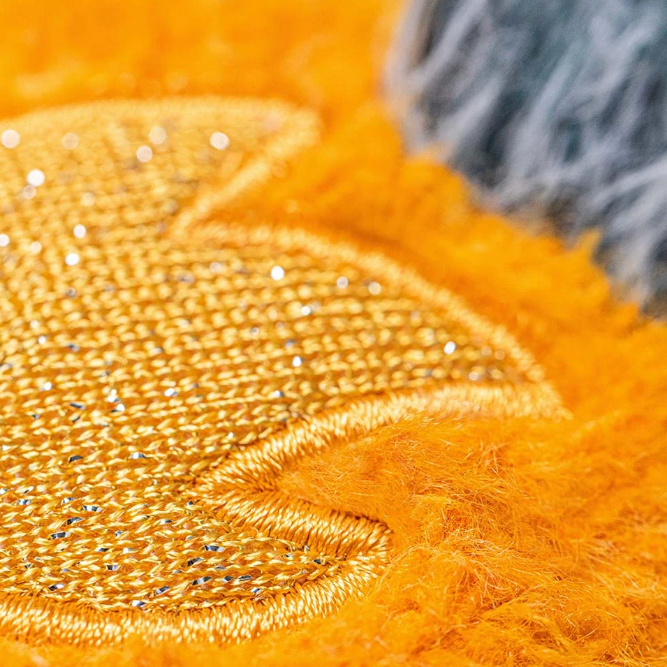 Close-up of a textured yellow fabric with embroidered design, labeled 'Amuseables Space Comet'.