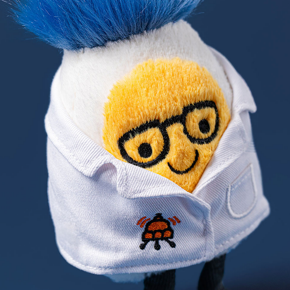 Plush toy with a face wearing glasses and a white shirt on a blue background