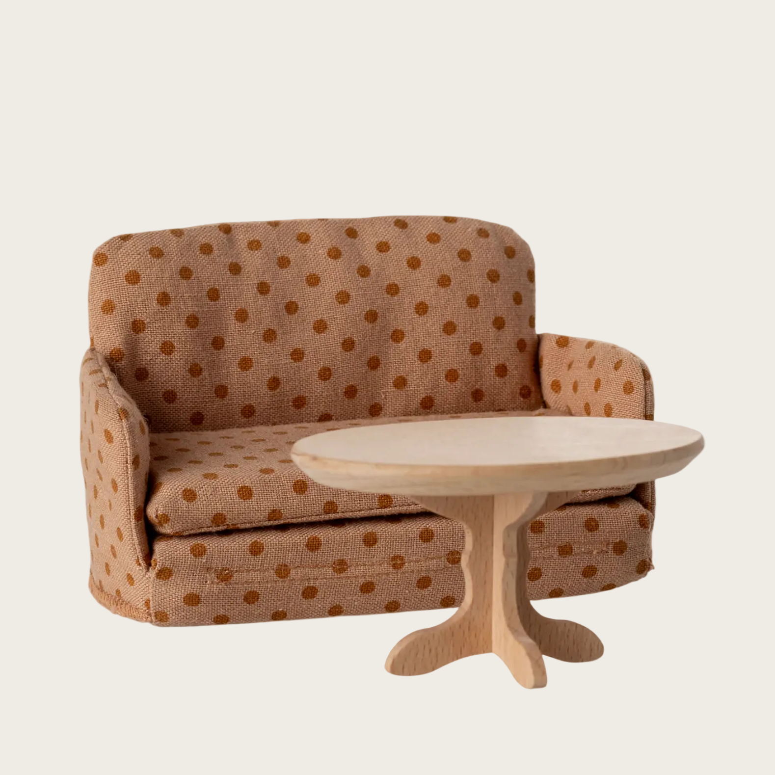 Brown polka dot sofa with a matching ottoman on a website page.
