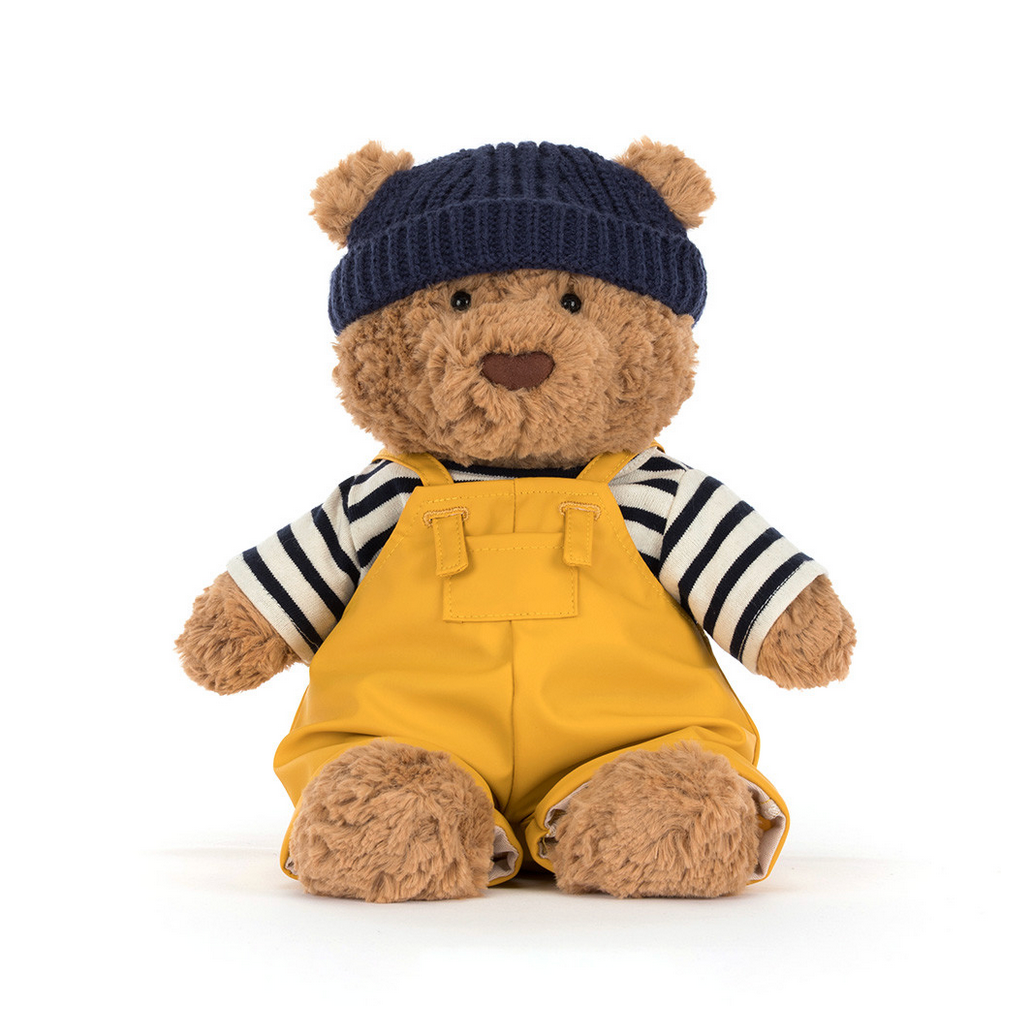Stuffed bear toy wearing a seafarer outfit with a blue hat on a white background