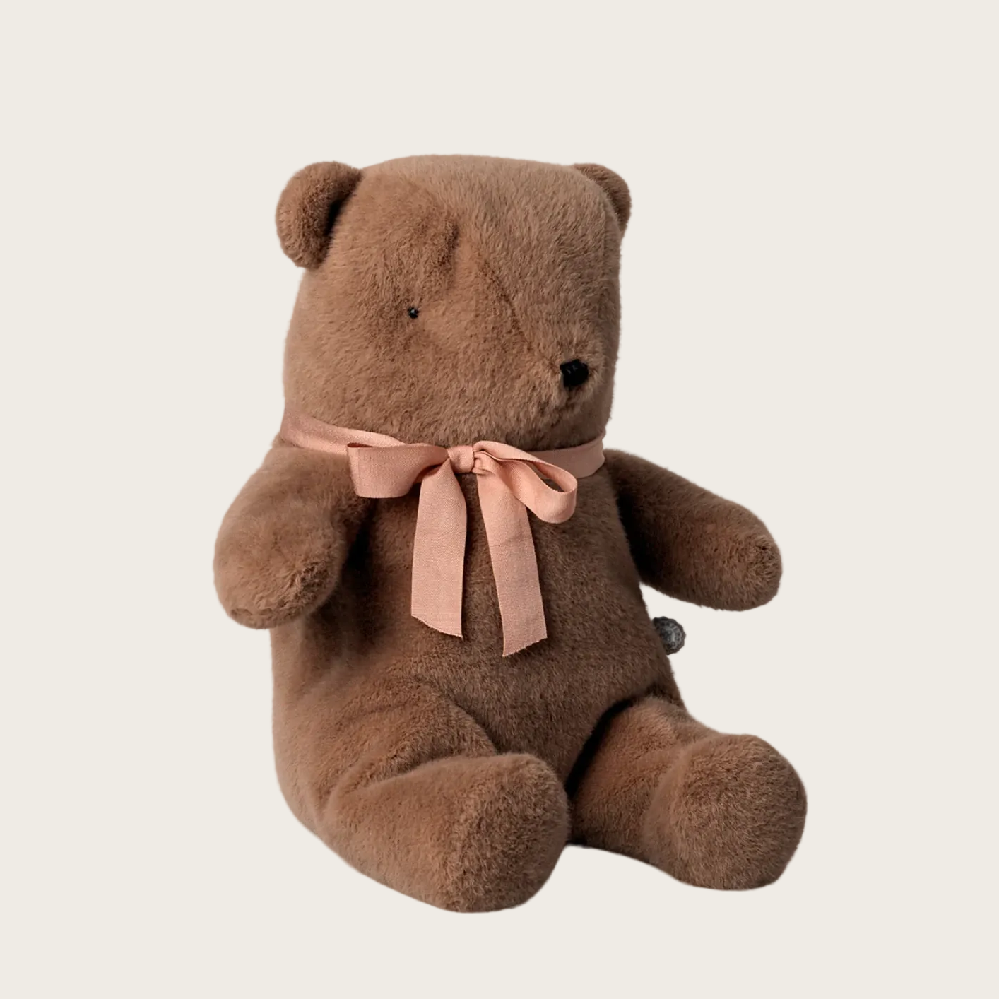 Brown teddy bear with a pink bow on a website page, likely a product listing.