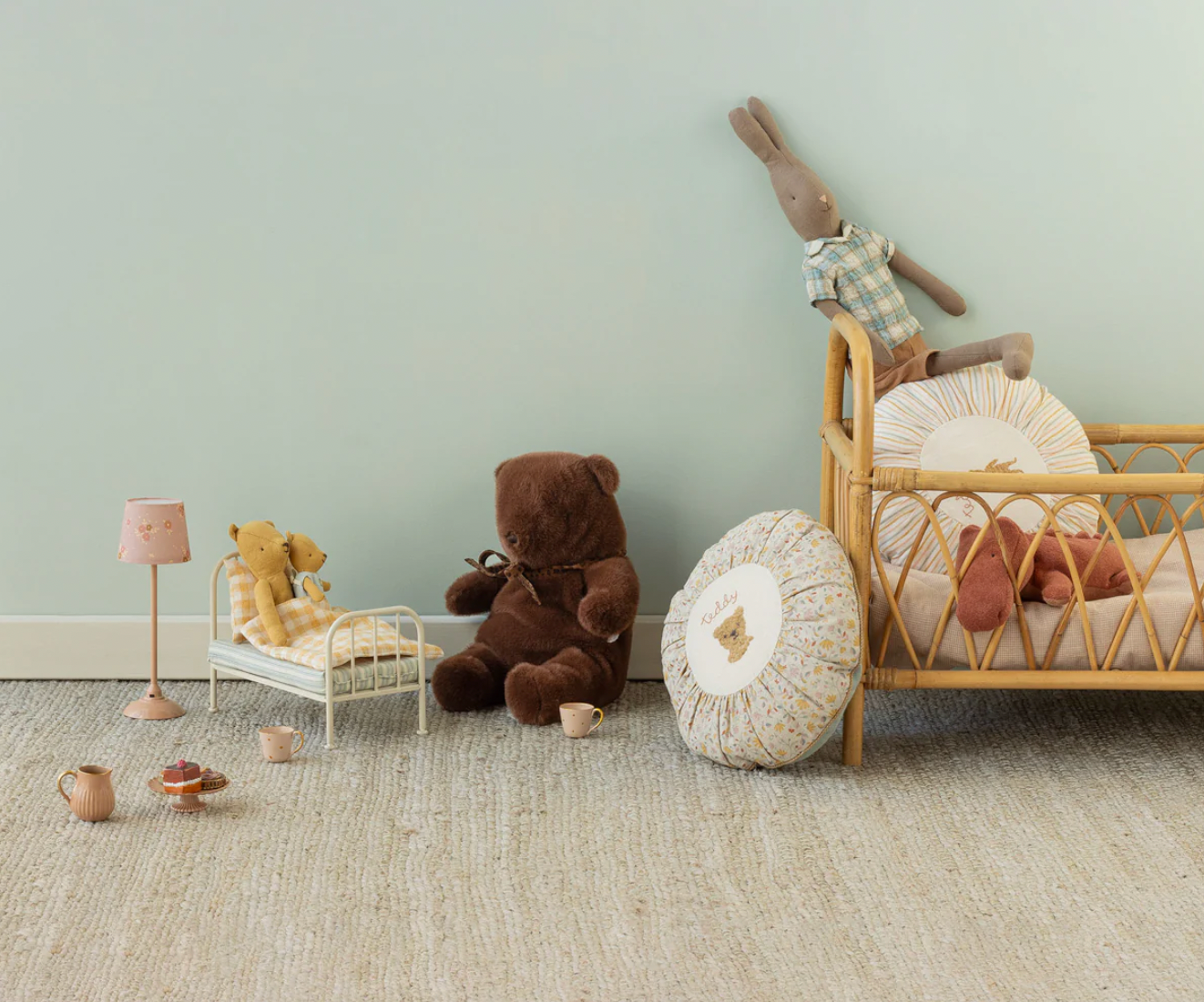 Children's room with toys and furniture against a light green wall.