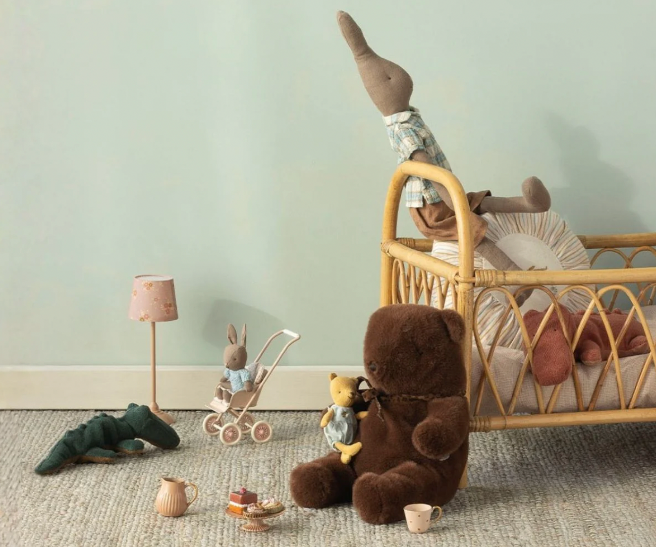 Children's room with toys and a crib against a light green wall.