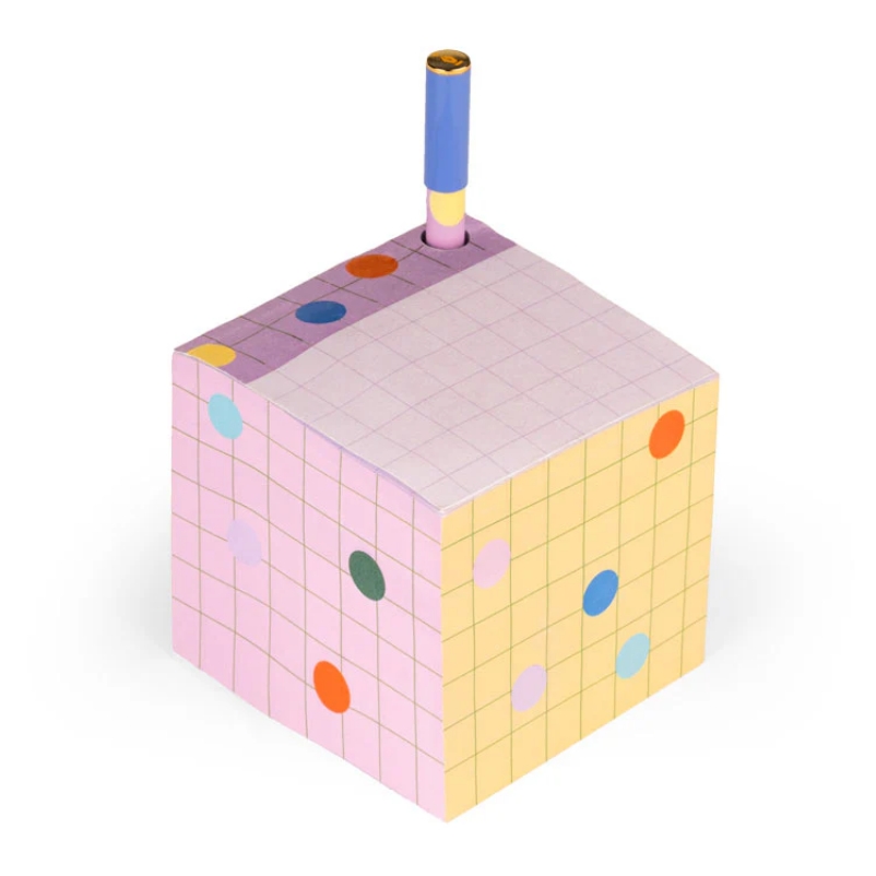Colorful cube-shaped notepad with a pen holder on a white background