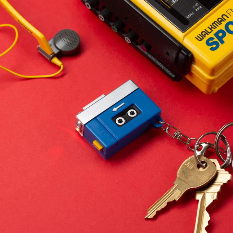 Blue cassette tape keychain with keys on a red background