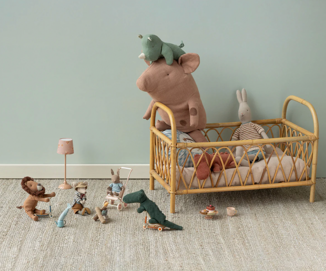 Children's room with a rattan crib, plush toys, and various small figurines on a light gray floor.