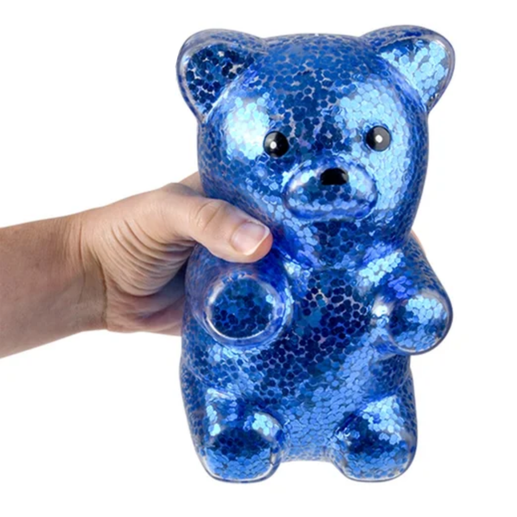 Blue gummy bear plush toy held by a hand with 'Rhode Island Novelty' branding.