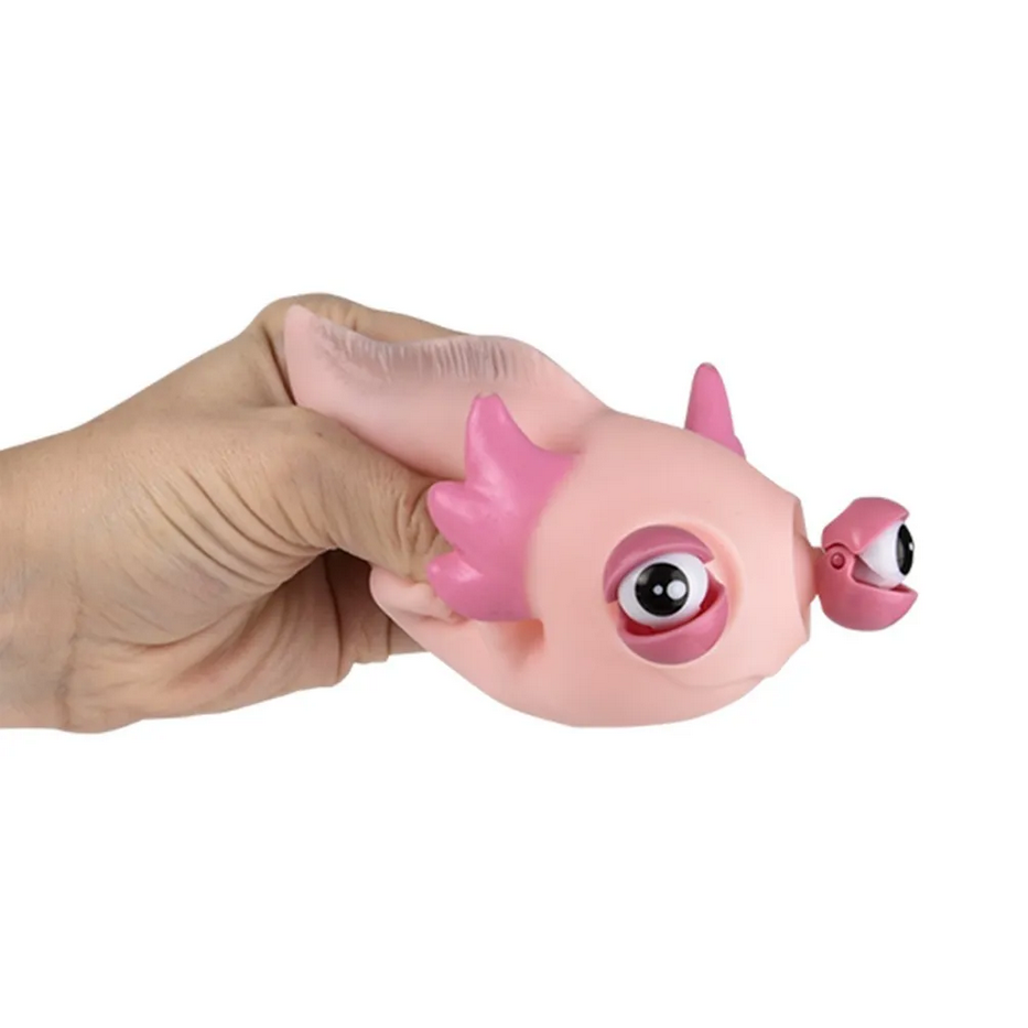 Pink toy resembling a creature with large eyes and a small body held in a hand against a white background