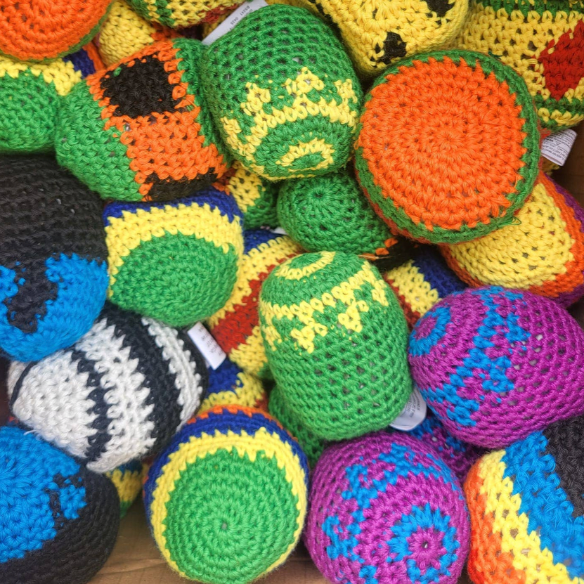 Colorful crocheted balls in various patterns and colors on a dark background