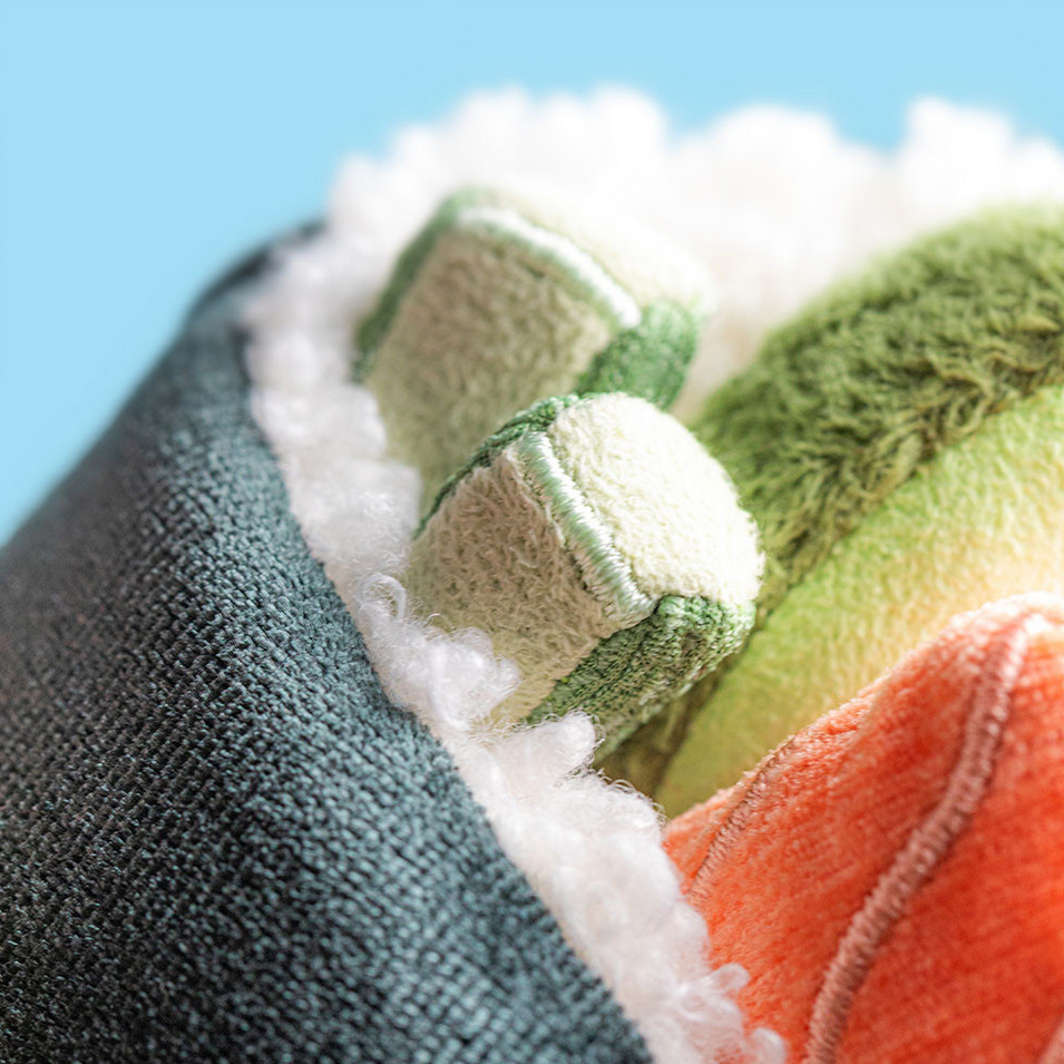 Close-up of textured fabric with green, orange, and white patterns against a blue background
