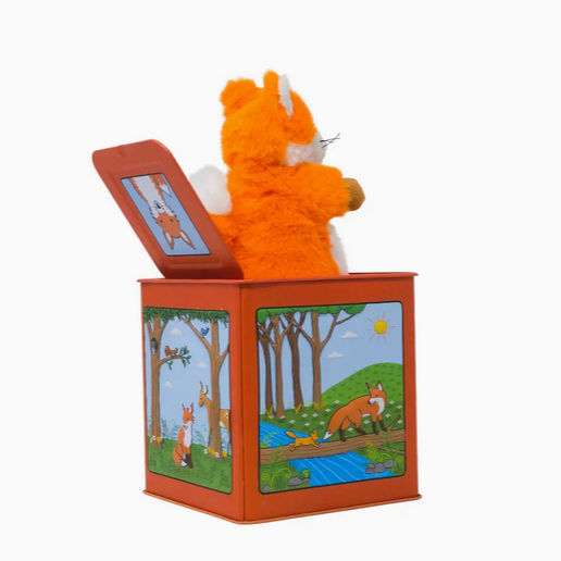 Orange teddy bear in a wooden box with illustrated scenes on a white background
