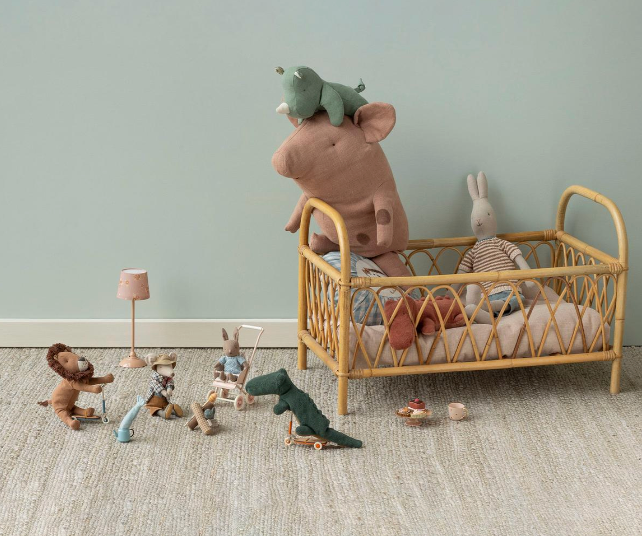 Children's room with a wooden crib, plush toys, and toys on the floor against a light blue wall.