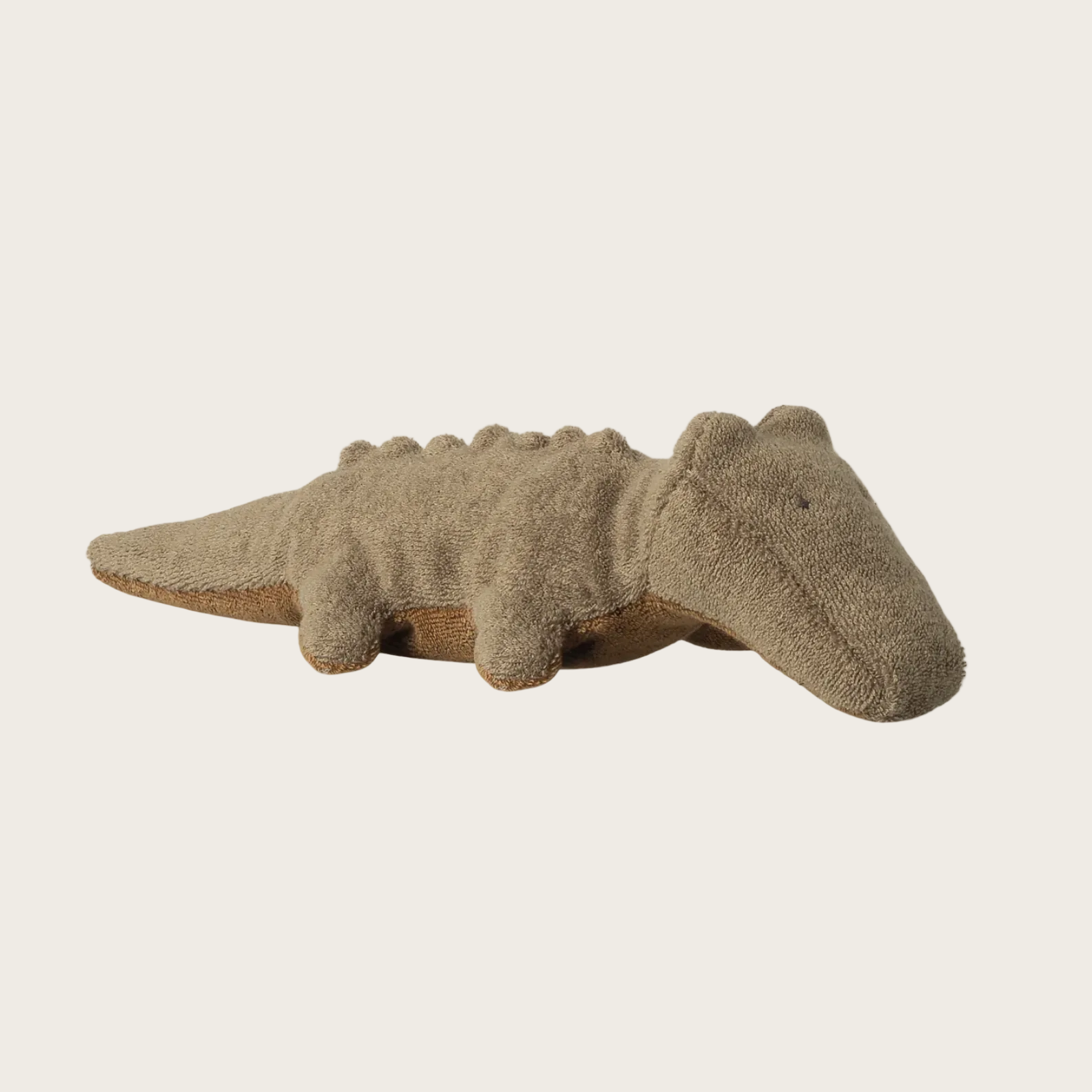 plush alligator toy on a beige background