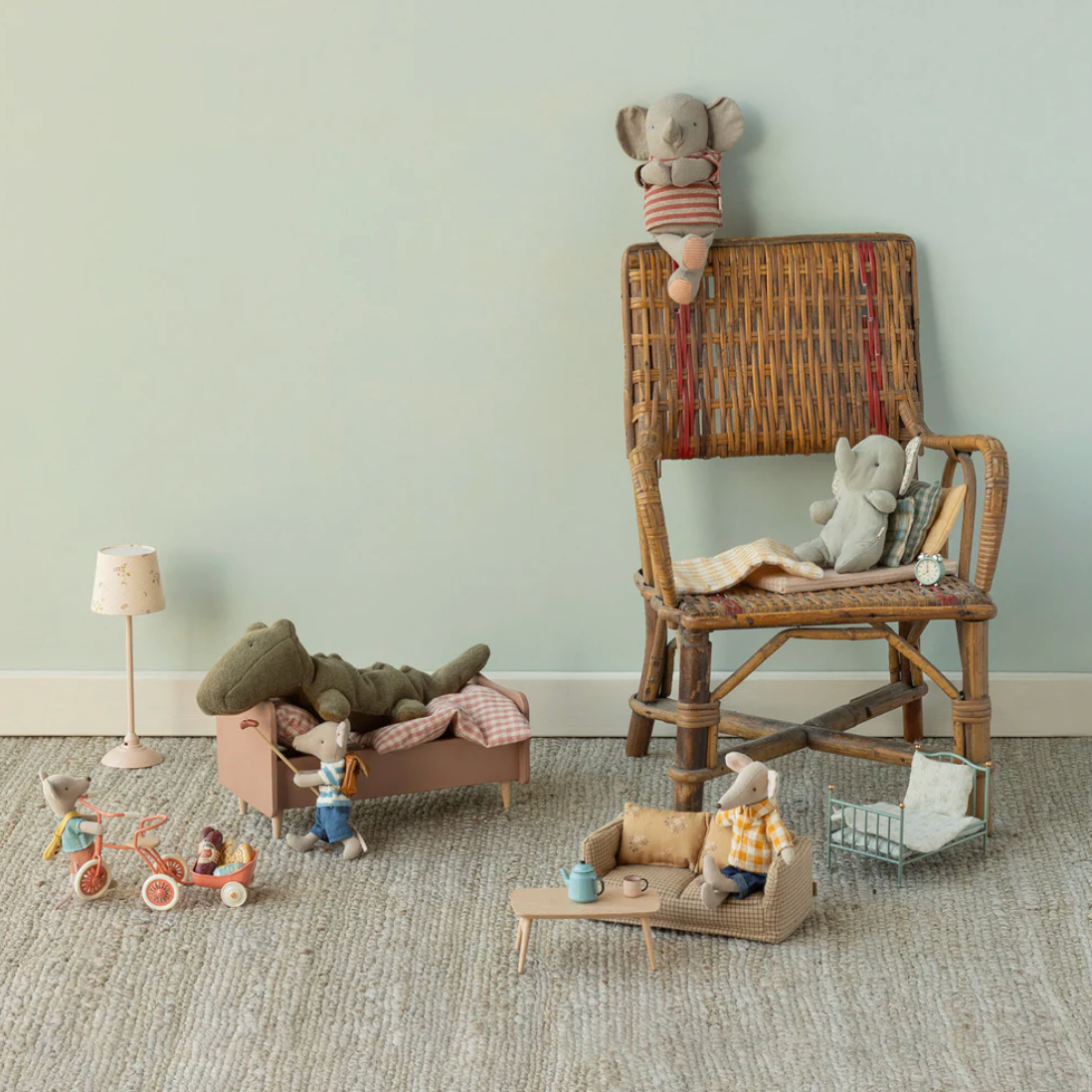 Children's toys on a wooden chair against a light green wall.