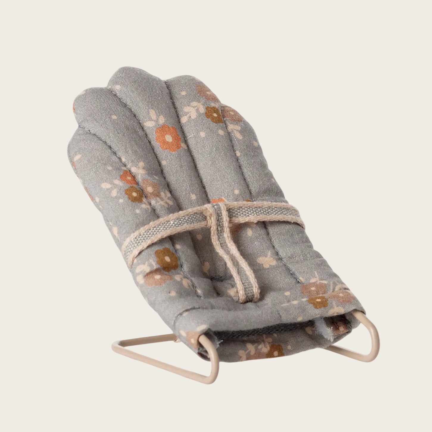 Foldable baby bouncer with floral pattern on a light gray background
