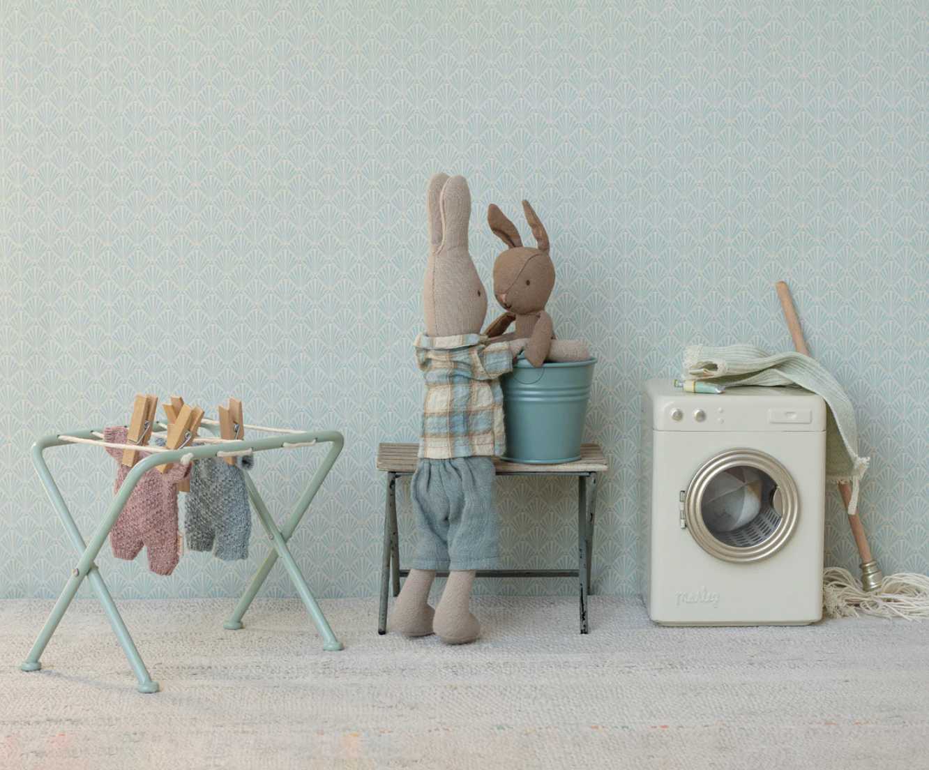 Children's room with stuffed animals, washing machine, and dryer against a light blue wall.