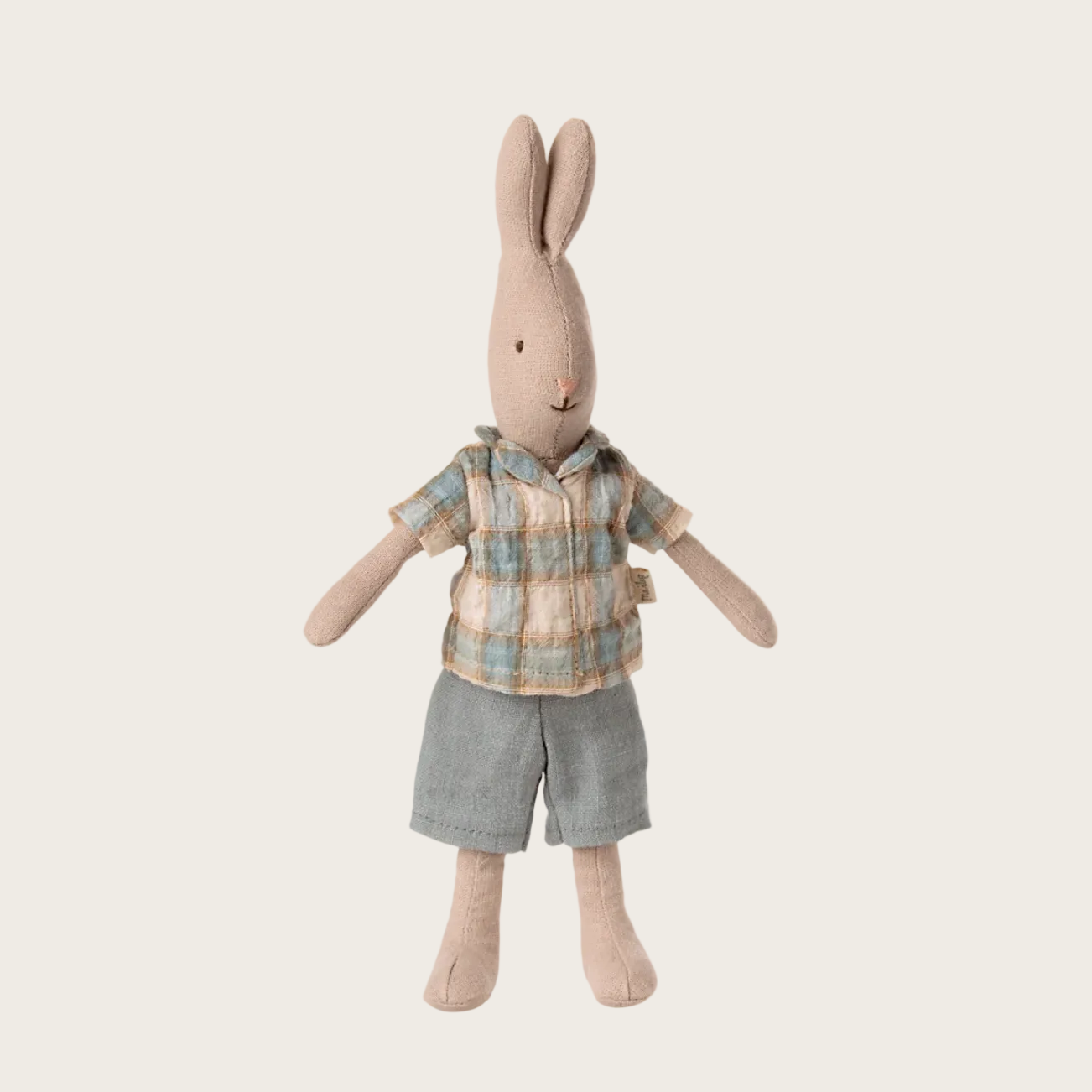 Stuffed rabbit toy wearing a plaid shirt and gray shorts 