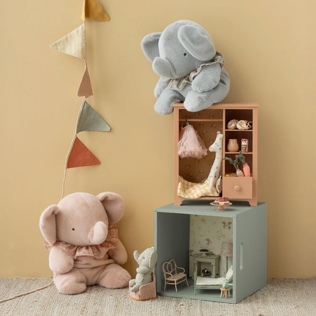 Children's room with plush elephant toys and a small wooden dollhouse.