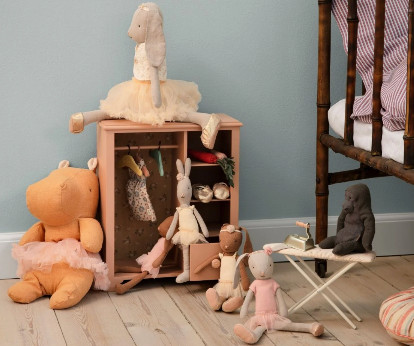 Children's toys and a small wooden cabinet against a light blue wall.