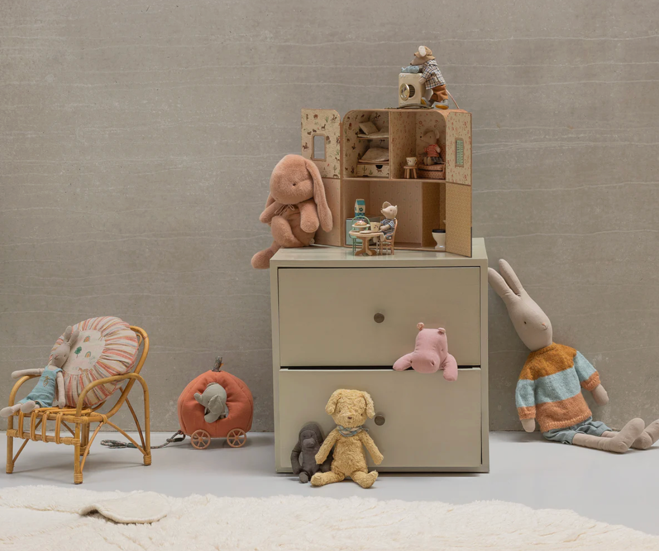 Children's room with toys and a small dresser against a neutral wall.
