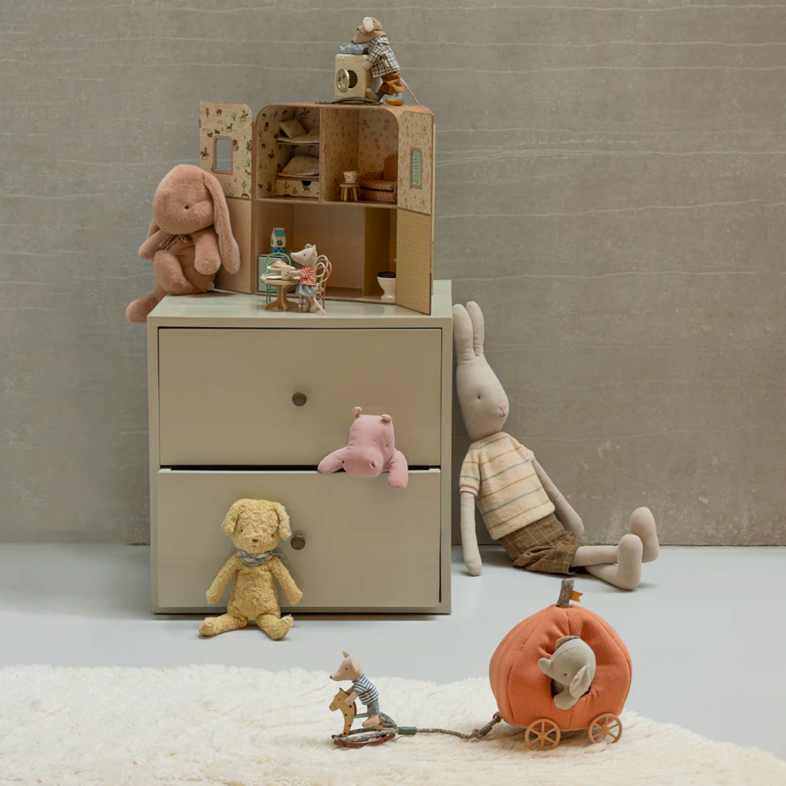 Children's toys and a small wooden cabinet on a neutral background