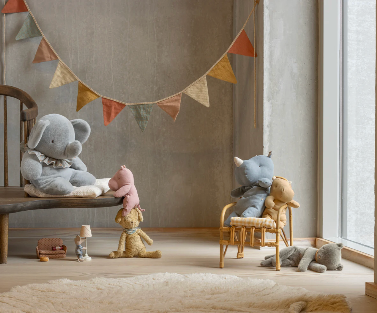 Children's room with stuffed animals and a decorative banner.