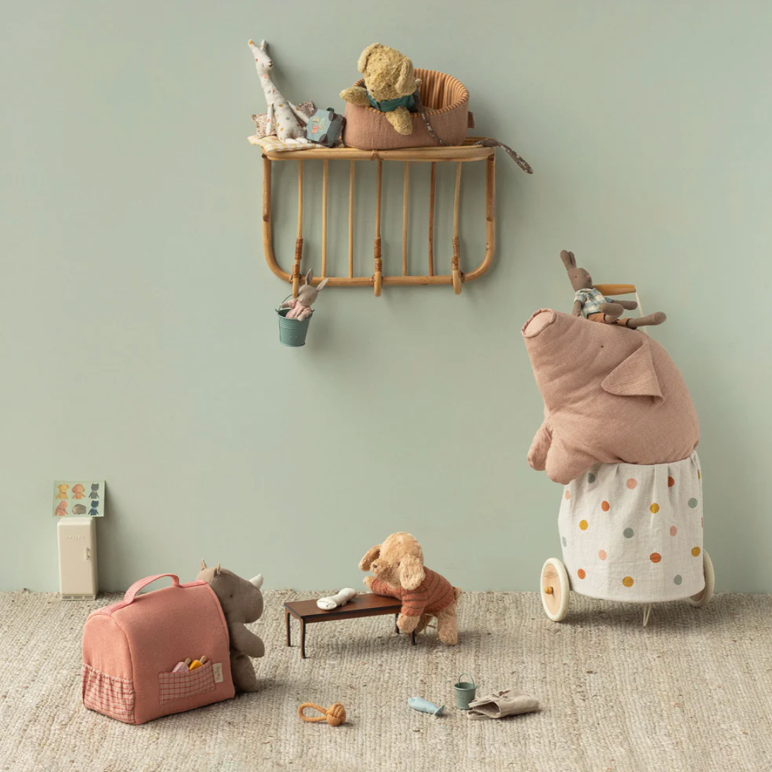 Children's room with toys and a shelf against a light green wall.