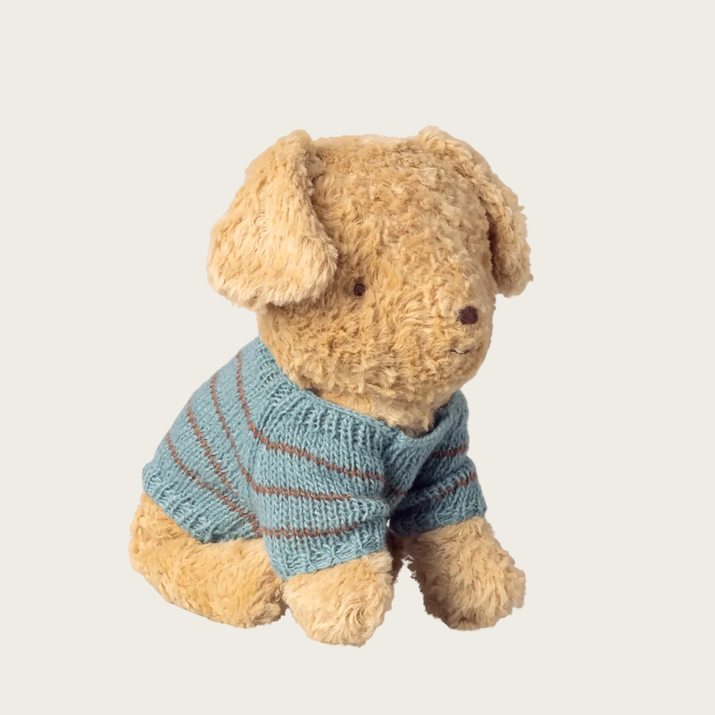Stuffed dog toy wearing a blue knitted sweater 