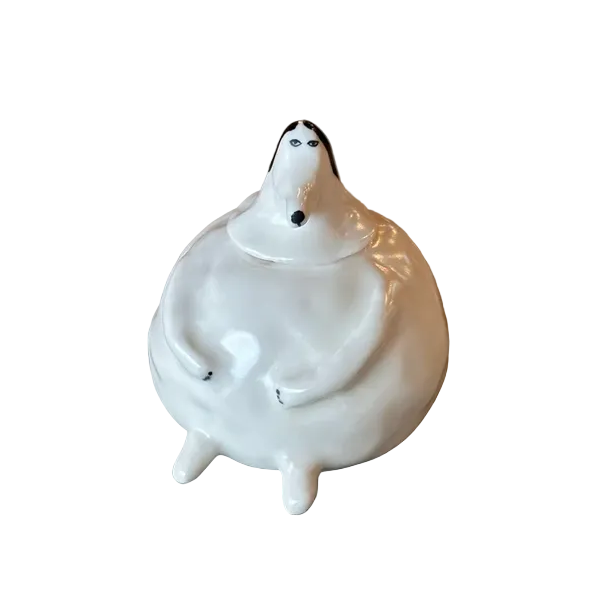 White ceramic figure of a person sitting on a stone surface