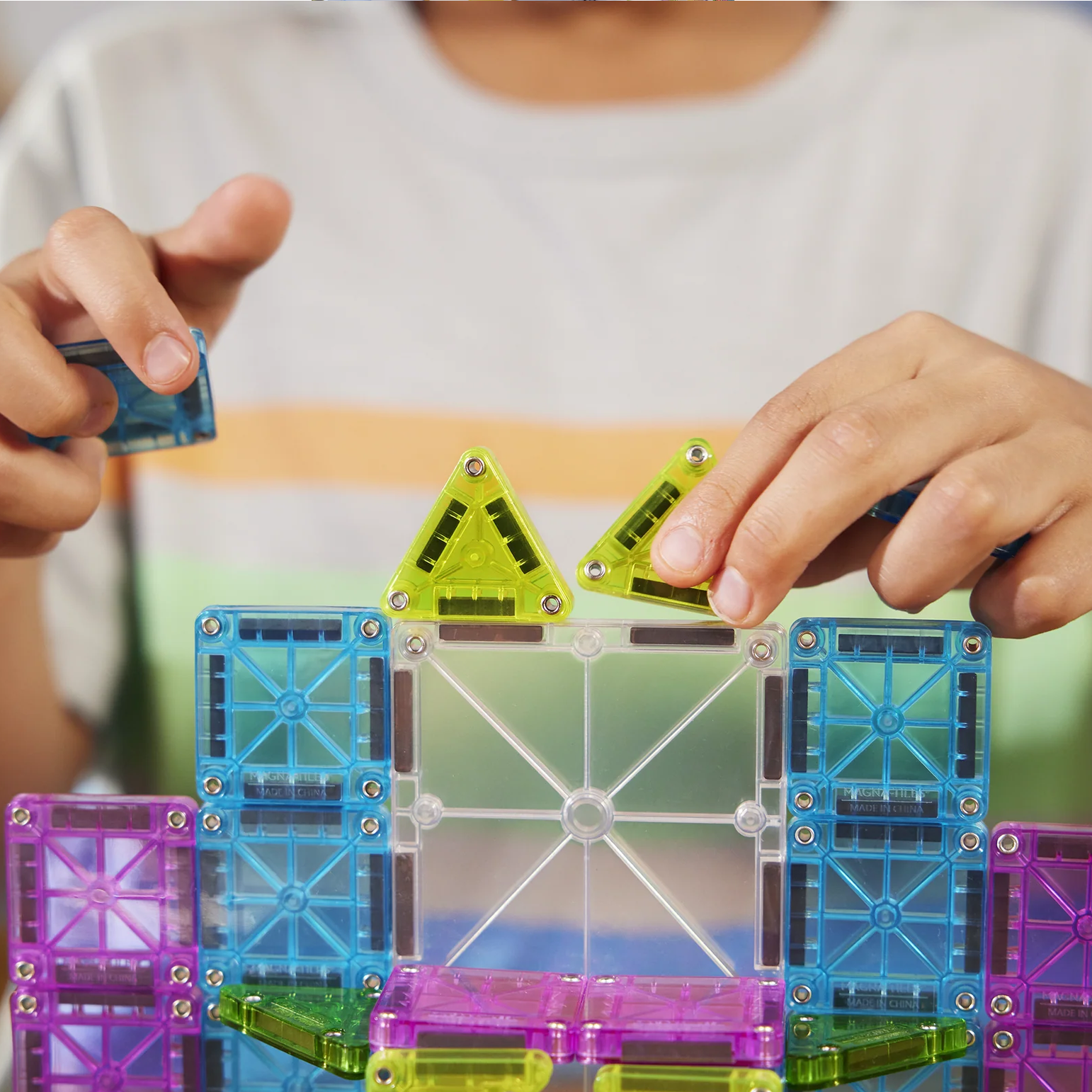Child playing with colorful magnetic building blocks