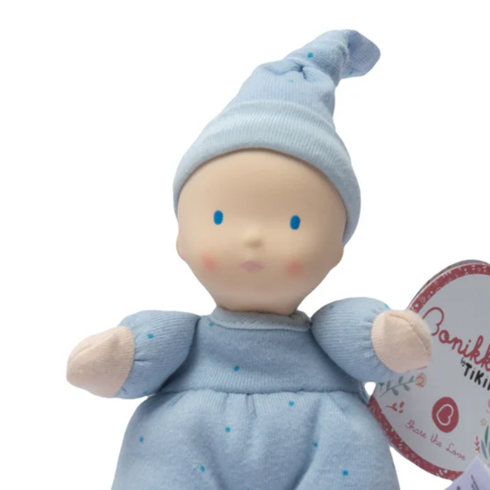 Baby doll in blue outfit with a visible brand tag on a white background