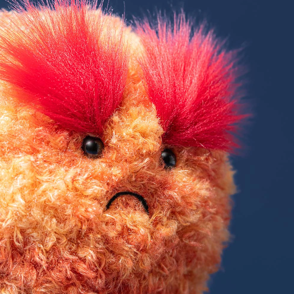 Plush toy with red hair against a blue background
