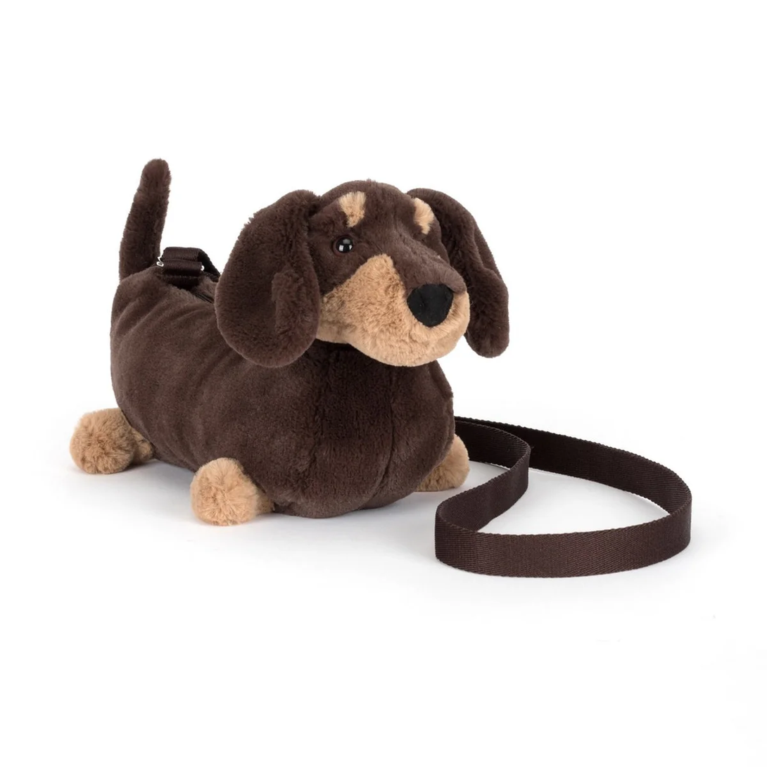 Plush dachshund toy with a leash on a white background