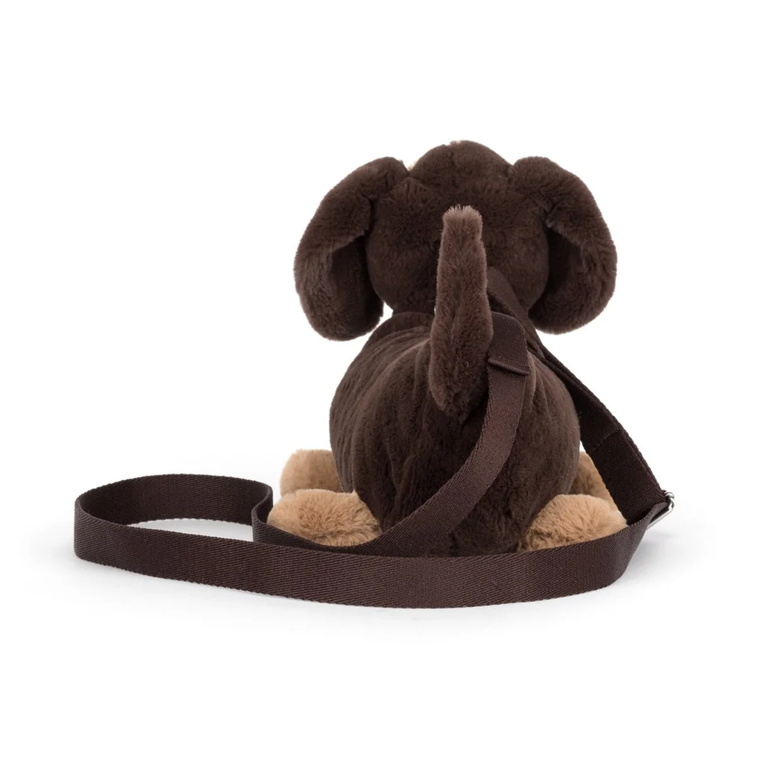 Brown plush dog with a strap on a white background