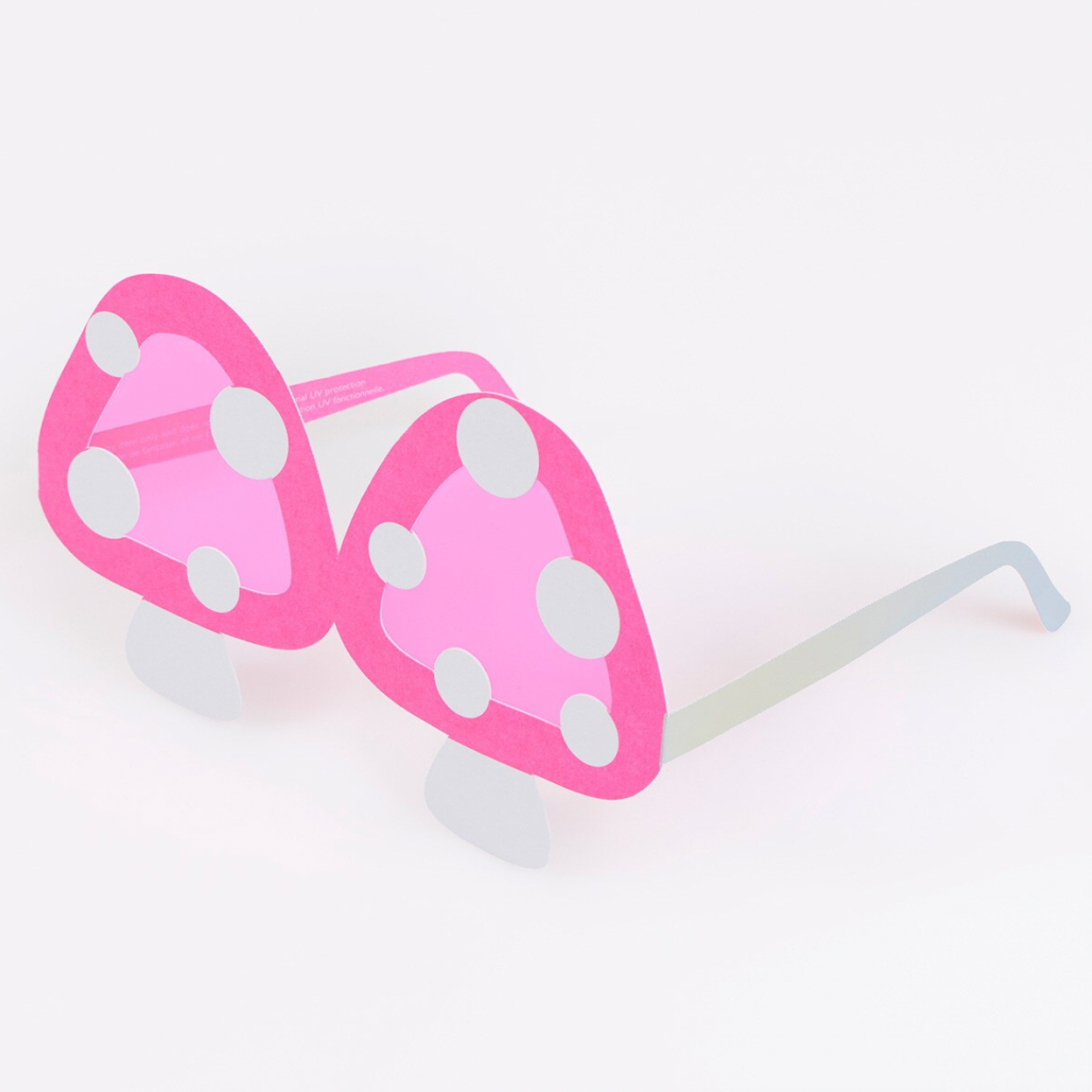 Pink sunglasses with white polka dots on a white background
