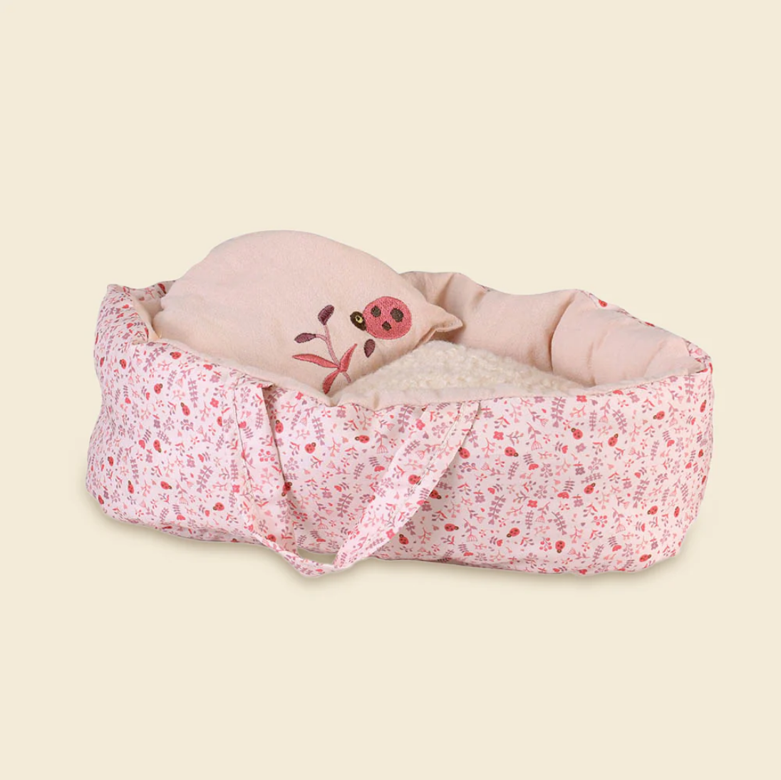 Pink baby swaddle with a ladybug design on a beige background