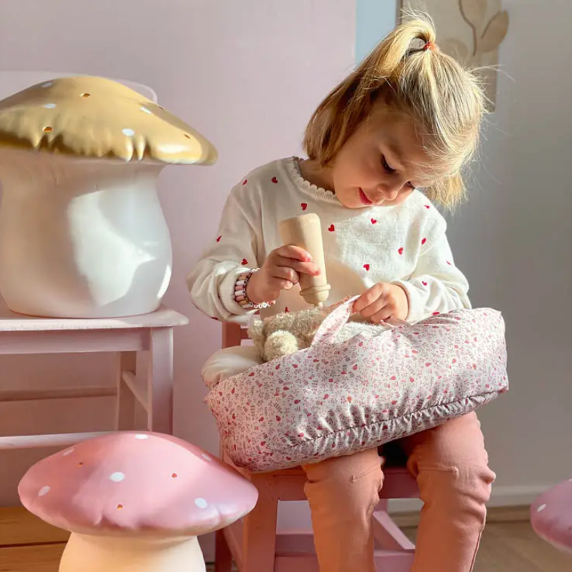 Child playing with a toy in a room with decorative mushroom lights.