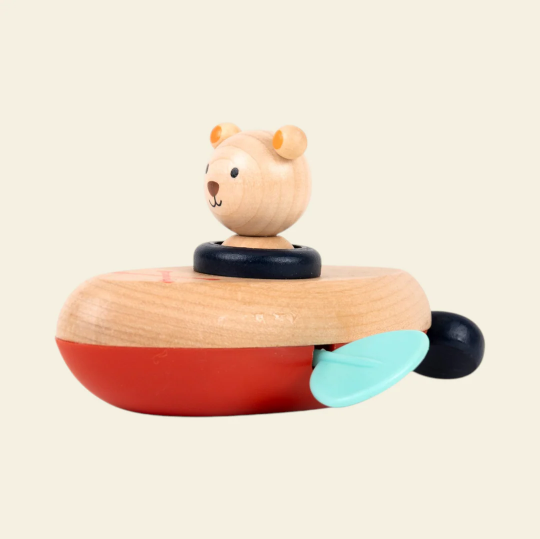Wooden toy boat with a bear figure on a beige background