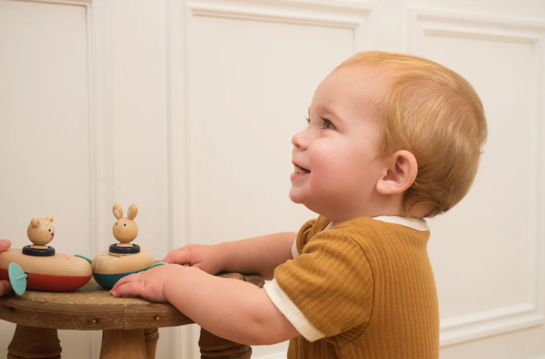 Child playing with wooden toys on a small table